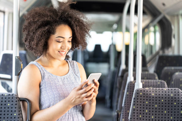 istock Smiling african woman text messaging in bus 1060675406
