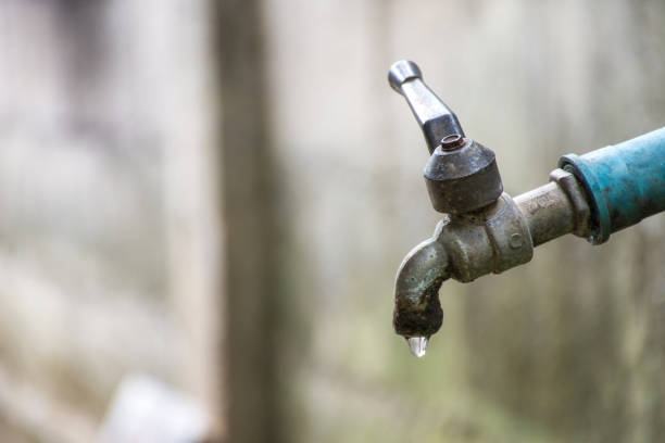 istock Old faucet with water leaking drop to the ground. 1060700498