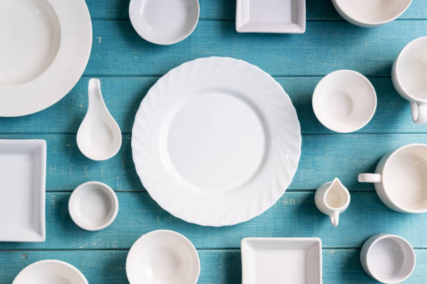 istock Various empty white plates and bowls on wooden background, Top view 1060716232