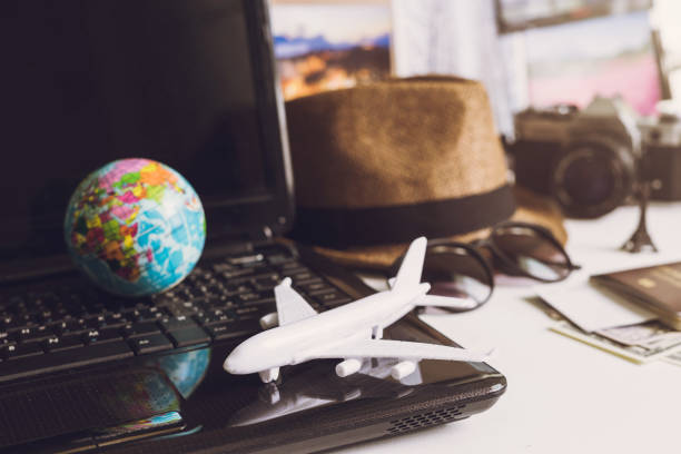 istock Toy airplane on laptop keyboard with globe and camera 1060716282