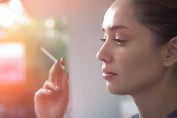 istock Beautiful woman smoking a cigarette outdoors close up 1060727978