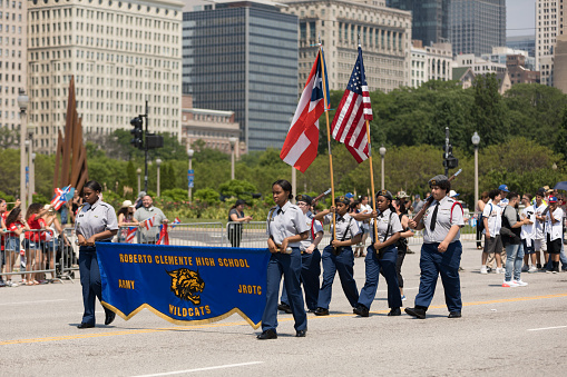 Chicago, Illinois, USA - June 16, 2018: The Puerto Rican Day Parade, Members of the Roberto Clemente High School with rifles carry the puerto rican and american flag