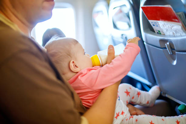 istock Father holding his baby daughter during flight on airplane going on vacations 1060741452