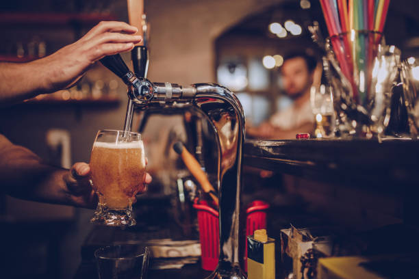Pouring beer Man in pub pouring beer. craft beer stock pictures, royalty-free photos & images