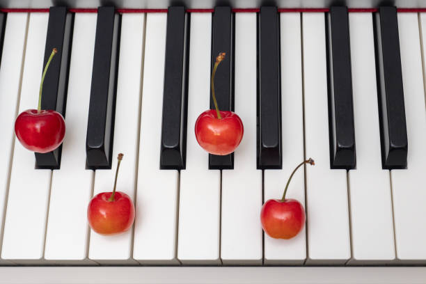 piano chord  shown by cherries on the keys - c#m7 (c sharp minor seventh) / dbm7 (d flat minor seventh) - c sharp minor imagens e fotografias de stock