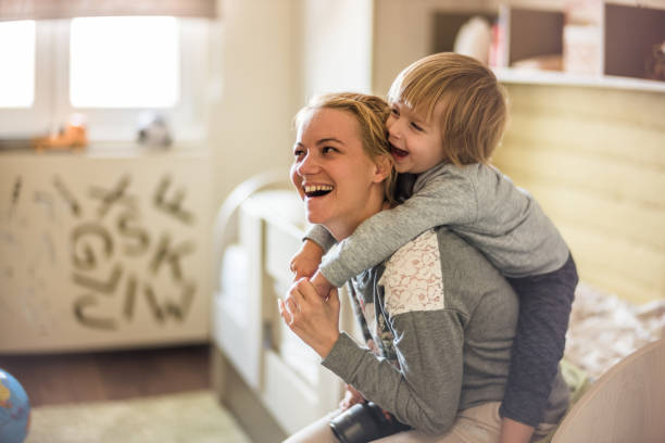 istock Playful mother and son piggybacking and having fun a home. 1060761238