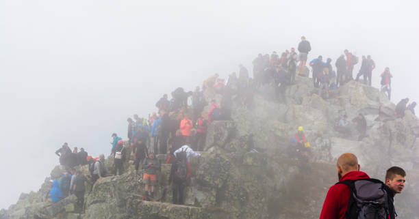 multitudes de turistas en la niebla en la parte superior de rysy. las montañas de tatra. - adulation little boys group of people teenage girls fotografías e imágenes de stock