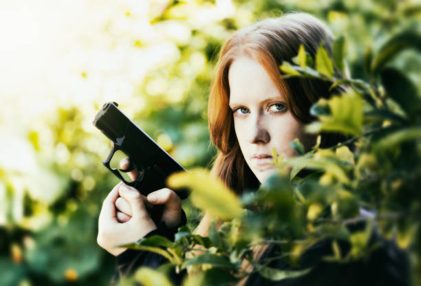 半自動ピストルで武装した若い女性が自分を守るために準備します。 - gun women semi automatic pistol young women ストックフォトと画像