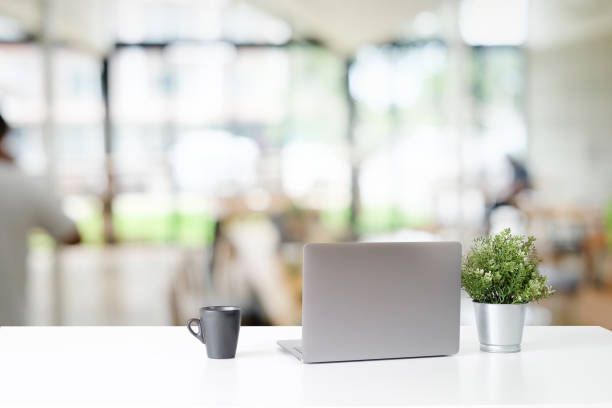istock Laptop computer and coffee cup on white table in office. 1060777208