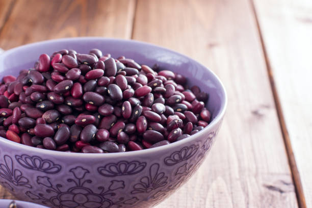 istock Red dry beans in a ceramic bowl on a wooden table, horizontal, copy space 1060777368