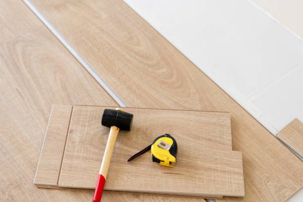 istock Installing laminate parquet in interior. On the floor lie different carpenter tools. Hammer and measuring tape. concept of repair in house. 1060782762
