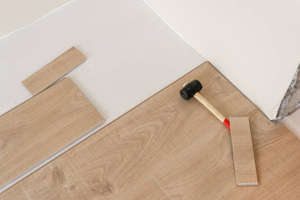 istock Installing laminate parquet in interior. On the floor lie different carpenter tools. Hammer and measuring tape. concept of repair in house. 1060782872