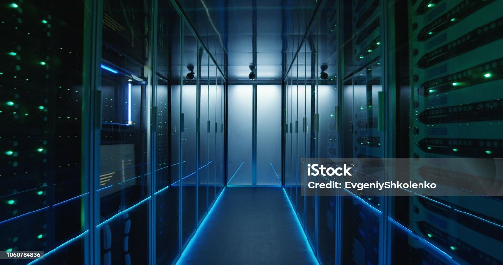 Long hallway full server racks in a modern data center Shot of a long hallway full server racks in a modern data center Network Server Stock Photo