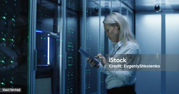 Female Technician Works On A Tablet In A Data Center Stock Photo - Download Image Now