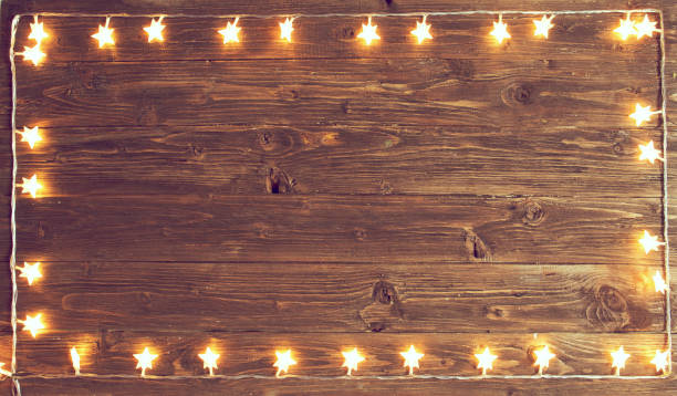 istock Merry Christmas! Christmas lights frame on wooden background with copy space 1060786008