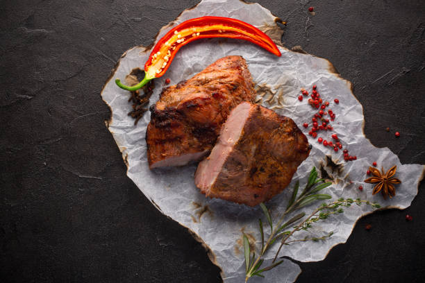 istock Baked meat with spices on black background 1060787124