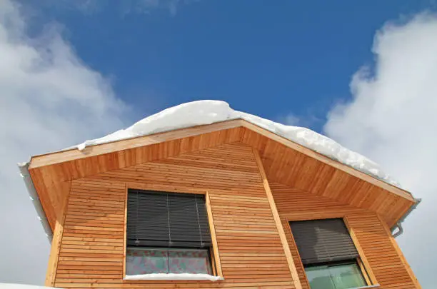 snow on the roof of wooden house