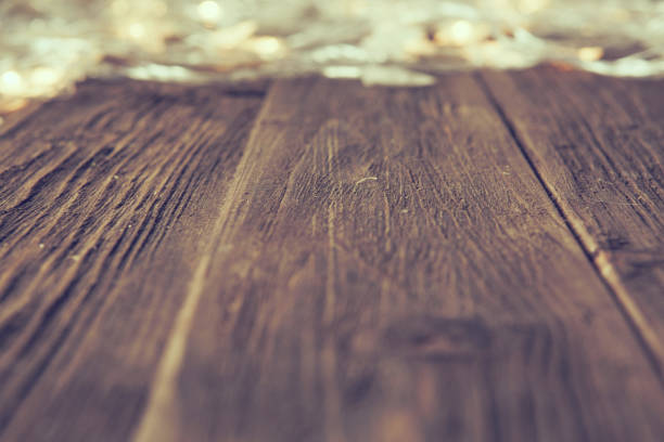 istock Christmas lights glowing on wooden table or floor background 1060787668