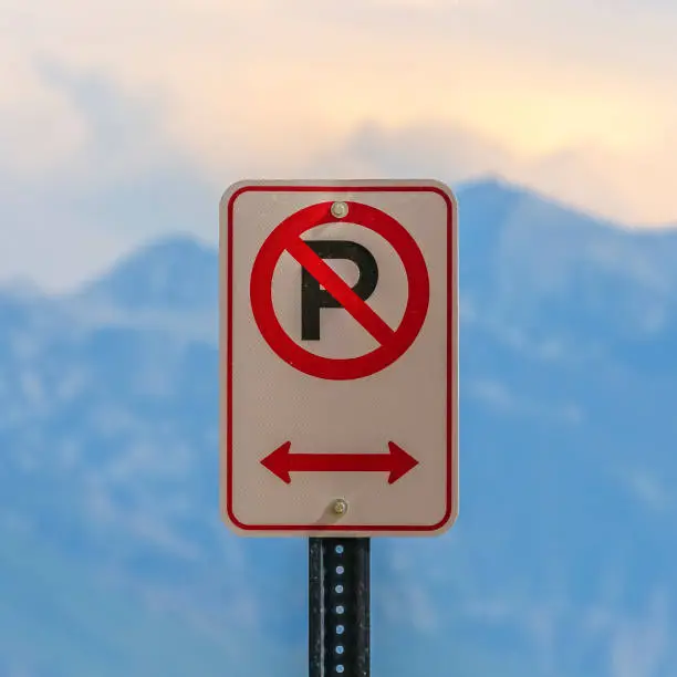 Photo of No parking sign against a blurry mountain and sky