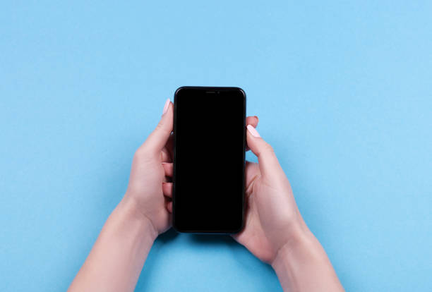 istock Top view of a woman hand using phone on blue background. 1060794918