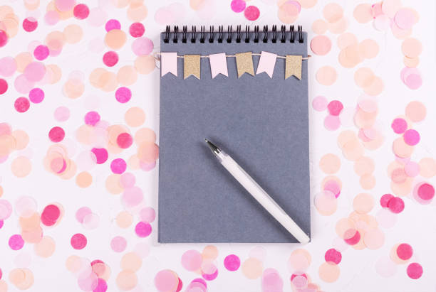 istock Planning concept. Festive confetti and notebook with wishlist on white background, flat lay style. 1060795472