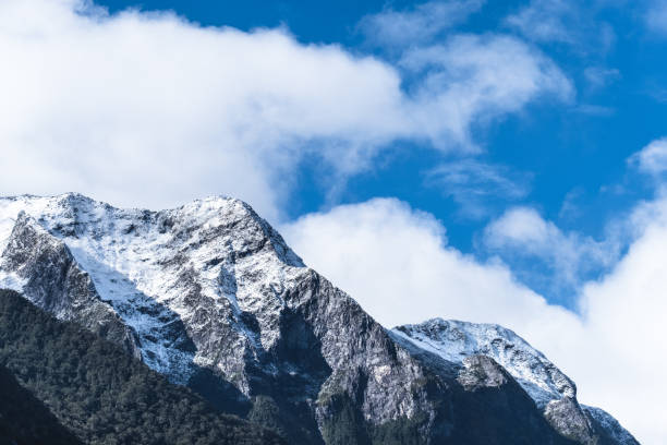 istock A rocky mountain covered with snow. Blue sky with some cloudy. 1060795788
