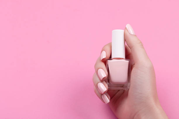 girl holds nail polish with a beautiful manicure girl holds nail polish with a beautiful manicure nail varnish stock pictures, royalty-free photos & images