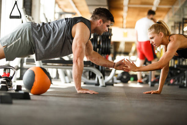 istock Man and woman doing push-ups together 1060797120