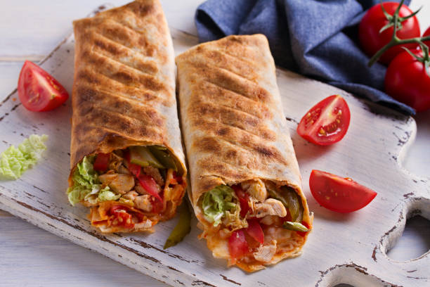 istock Chicken wraps with tomatoes, pickles, cabbage and onion. Tortilla, burritos, sandwiches, twisted rolls 1060797536