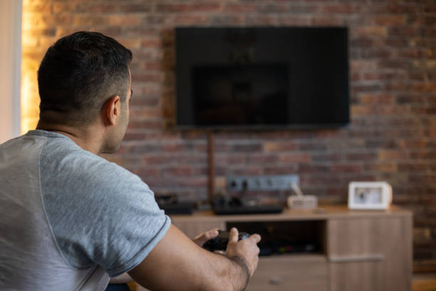 istock Happy young man at home playing video games 1060803004