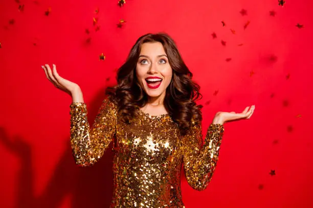 Photo of Careless, carefree, dream, dreamy concept. Photo of stylish, trendy modern lady with wave hairstyle isolated on bright red background raised hands up rest, relax on December night party