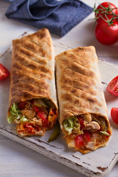 istock Chicken wraps with tomatoes, pickles, cabbage and onion. Tortilla, burritos, sandwiches, twisted rolls 1060806822