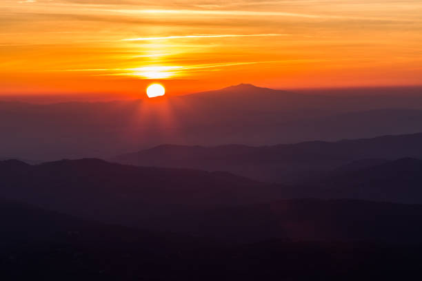 istock Beautiful sunset with sun coming down behind various layers of mountains 1060808656