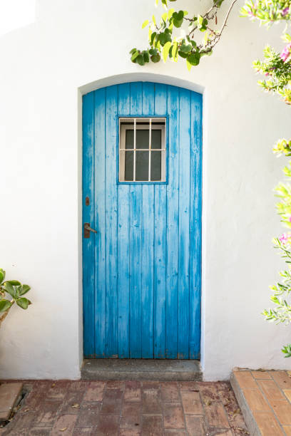blue wooden plank entrance door wooden plank door painted in blue on Ibiza Island in the Village of Puig de Missa - Santa Eulària des Riu. rustic door stock pictures, royalty-free photos & images