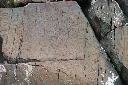 Petroglyphs of tailed people with semi-circular head and huge beast with a toothy maw at Kalbak-Tash,Russia.This monster was a devourer of souls,which cleansed them from the defilment before entering the upper world.