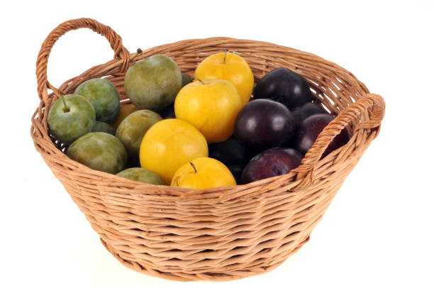 Basket of plums on a white background
