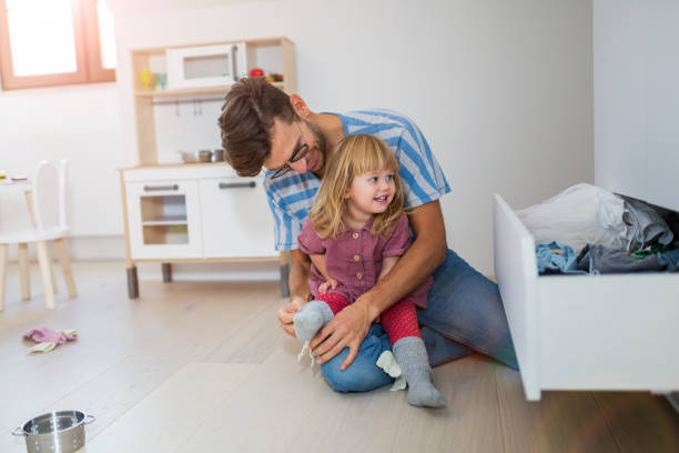 istock Dad is helping toddler daughter to get dressed 1060819390