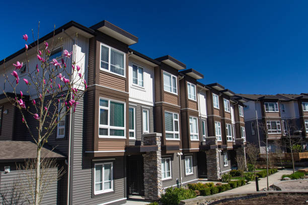 edificio de nueva construcción apartamento en día soleado en primavera con la floración de árboles. - townhomes fotografías e imágenes de stock