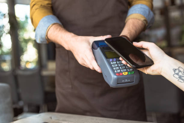 istock cropped shot of waiter holding payment terminal while customer doing contactless purchase with smartphone in cafe 1060823078