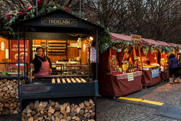 Kiosks with food and souvenirs in Old Town of Prague. PRAGUE, CZECH REPUBLIC - DECEMBER 12, 2016: Kiosks with souvenirs, hot drinks and traditional trdelnik spit cakes on the street of Old Town of Prague during famous annual Christmas Market. trdelník stock pictures, royalty-free photos & images