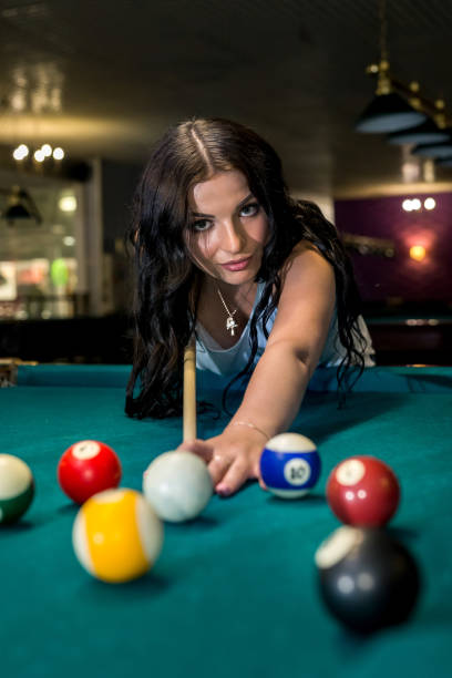 istock Pretty and young woman playing billiard in pub 1060824194