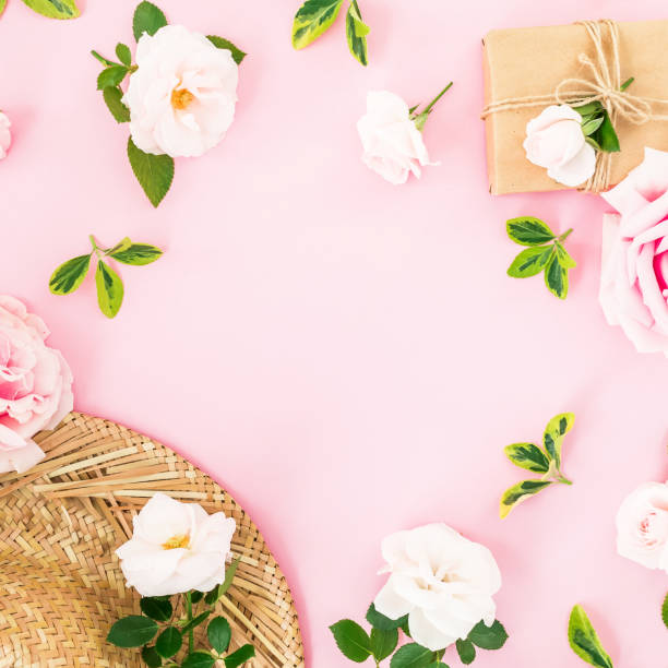 istock Valentines day composition. Floral frame with roses, straw hat and gift box on pastel pink background. Flat lay, top view. 1060830876