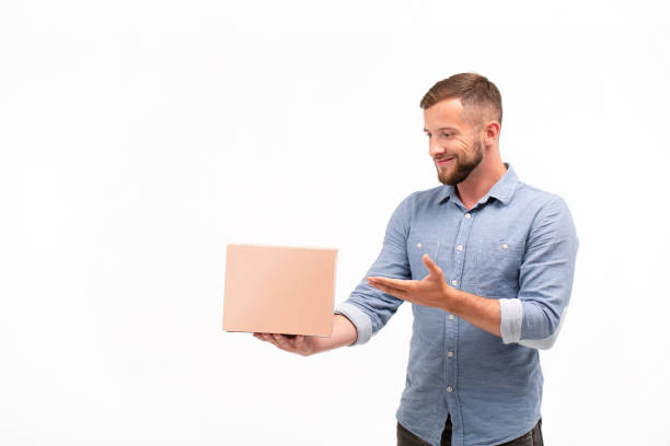 istock Casual young man holding a box isolated on a white background 1060830938