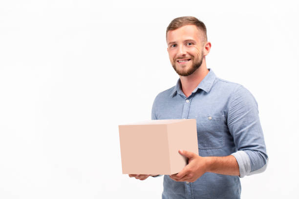 istock Casual young man holding a box isolated on a white background 1060830954