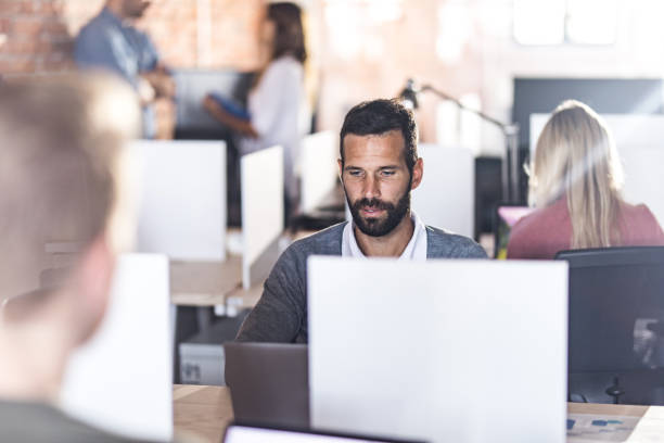 istock Young businessman working on laptop at corporate office. 1060834748