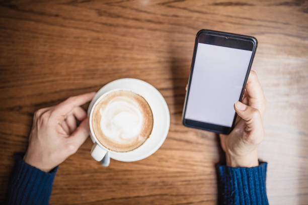 istock Young woman drinking coffee and using mobile phone in cafe 1060834942