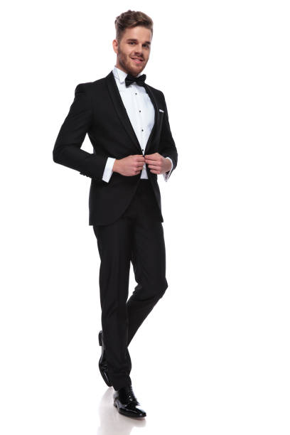 istock smiling young groom buttoning his tuxedo 1060835460