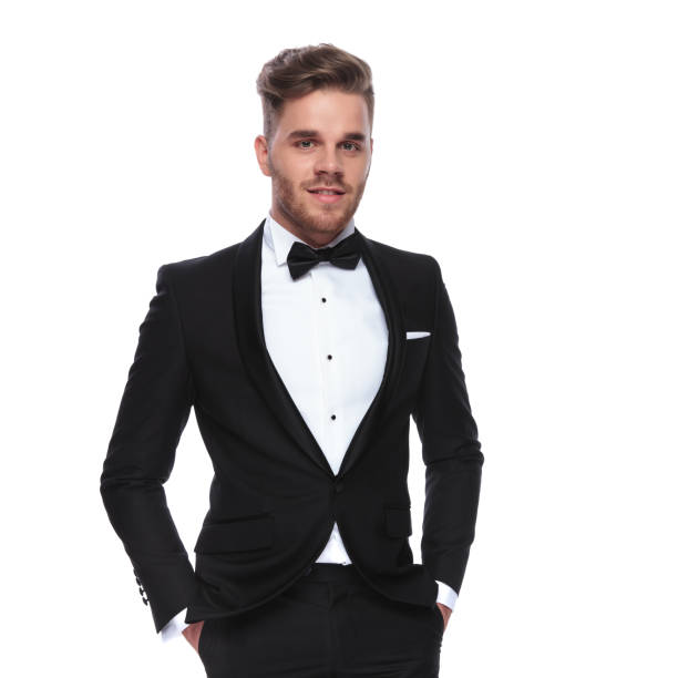 istock smiling elegant man in tuxedo standing with hands in pockets 1060835506