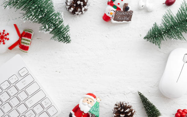 istock Flat lay Office desk table with computer wireless mouse and keyboard and Christmas decoration toys and ornaments on rustic white wooden background. Top view with copy space. 1060837990
