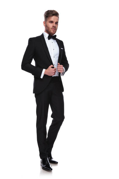 istock young elegant man puliing his tuxdo's collars while looking away 1060838126
